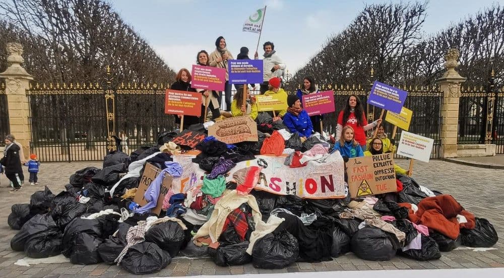 Activists standing on the landfill out of clothes