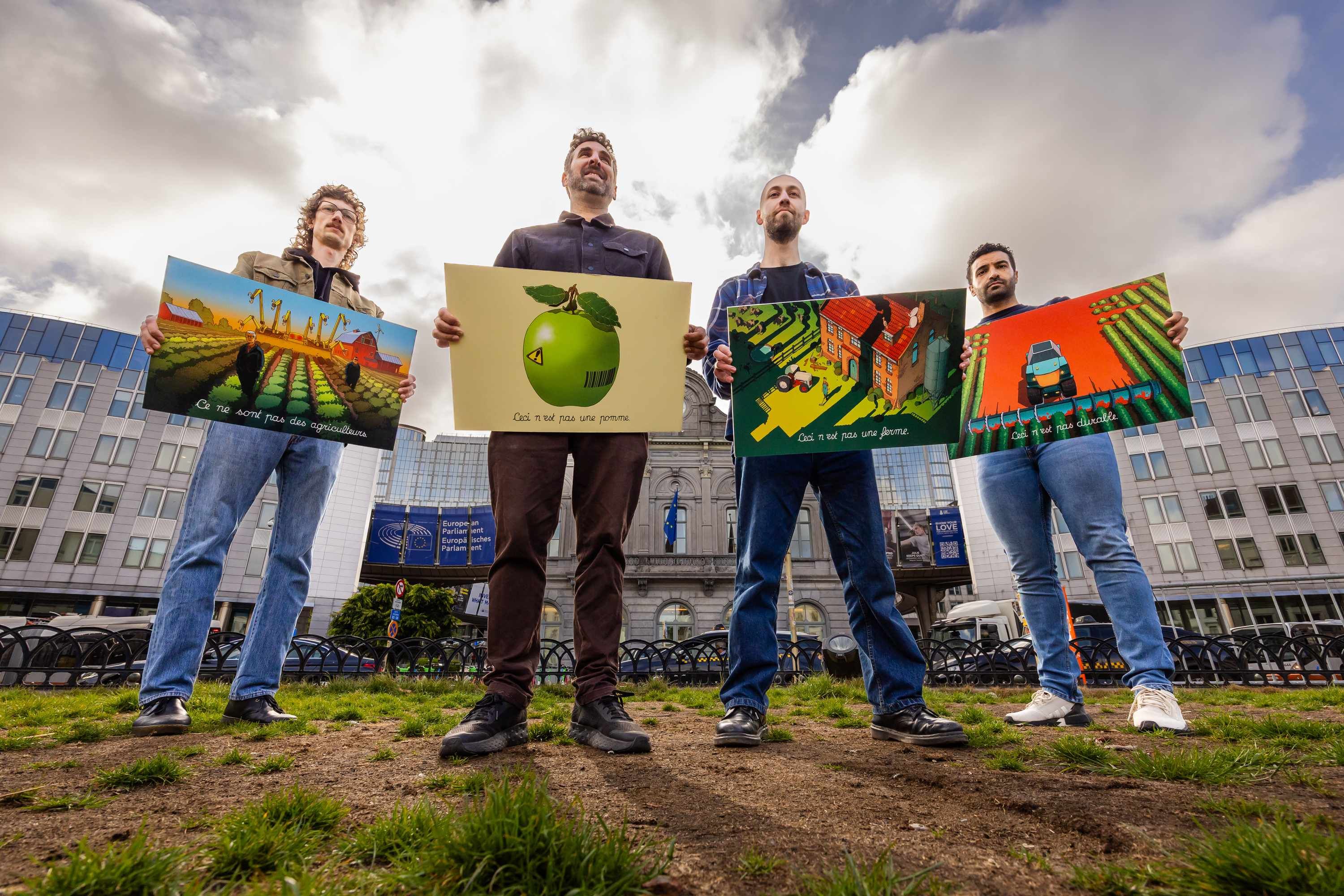 Activists including from WeMove Europe unveil the artwork next to the European Parliament