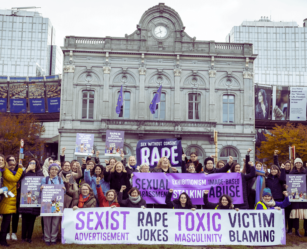 Kobiety stoją z transparentem wzywającym koniec przemocy wobec kobiet