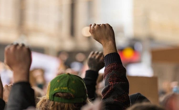 Grupa ludzi podnoszących pięści w geście protestu.