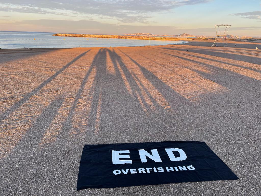 Ein Handtuch mit der Schrift ,,Stoppt die Überfischung" am Strand von Marseille. 