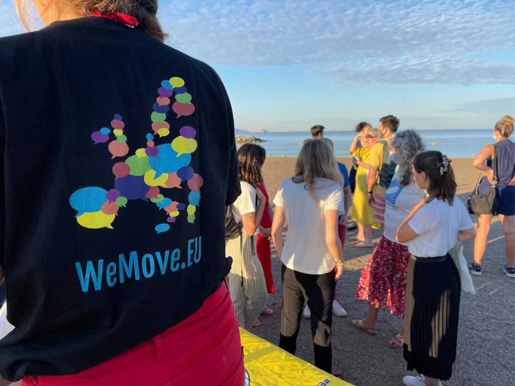 Die Teilnehmer bereiten sich auf das Schwimmen vor. Im Vordergrund trägt jemand ein T-shirt von WeMove Europe