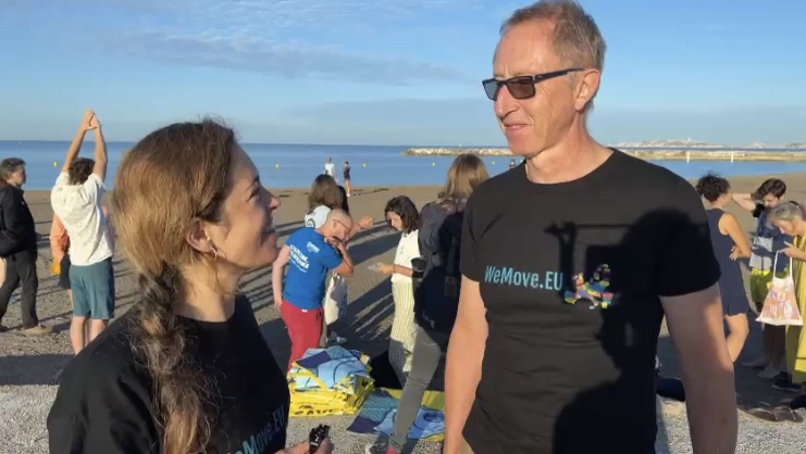 Mika, eine Koordinatorin von WeMove Europe, steht am Strand und spricht mit dem Segler Laurent über seine Erfahrungen. Mika, eine Koordinatorin von WeMove Europe, steht am Strand und spricht mit dem Segler Laurent über seine Erfahrungen.