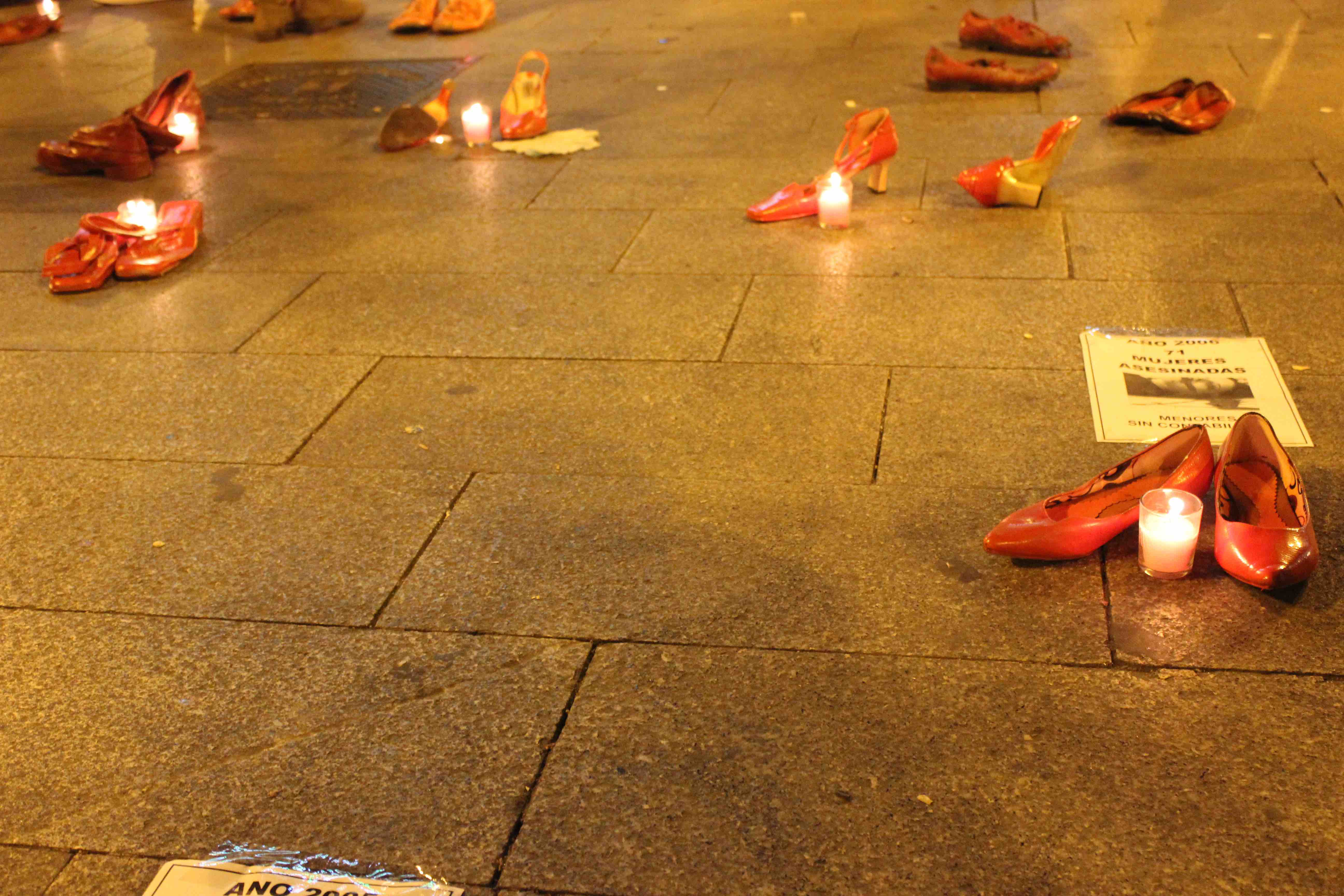 Shoes and candles laid out in memory of women killed in Europe