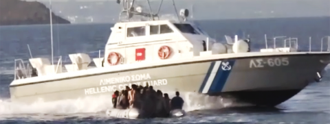 Barco en el mar, pequeña balsa salvavidas al frente, en el centro, con grupos de personas en ella.