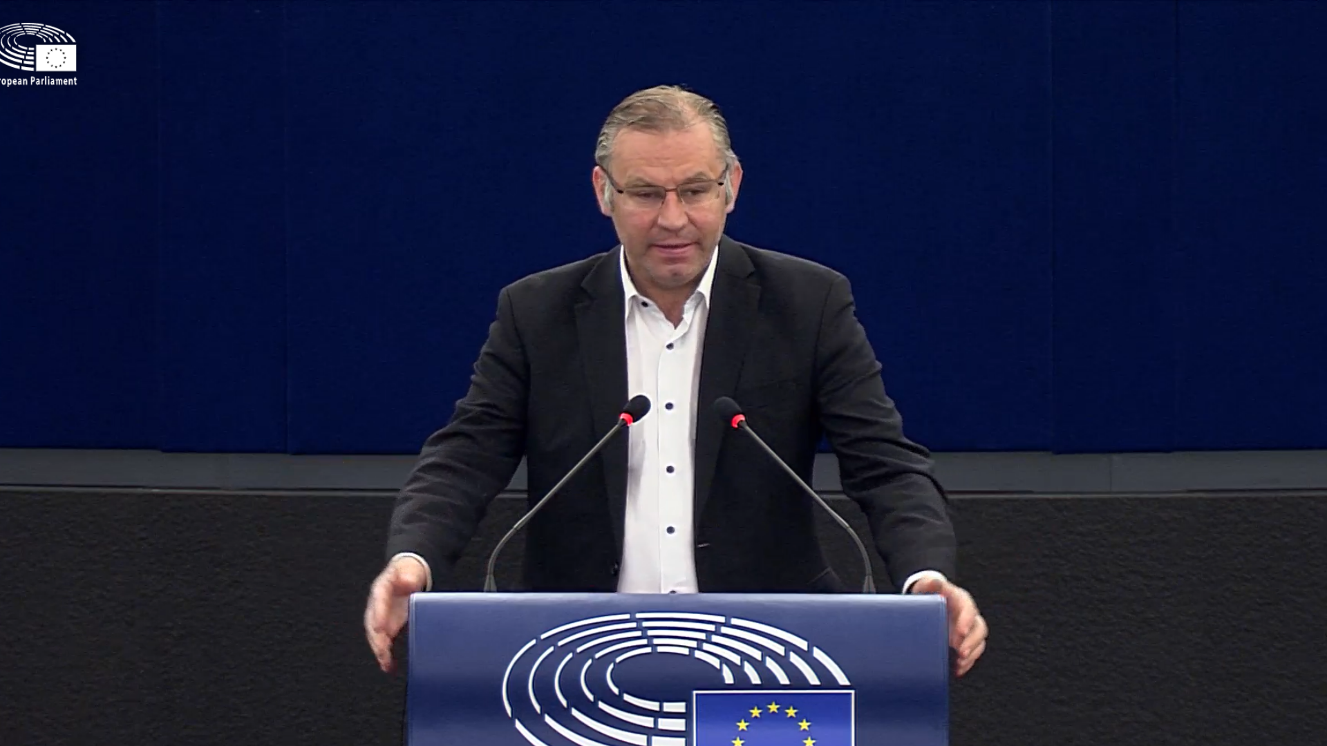 Standbild aus Video, MEP Norbert Lins steht in der Mitte an einem Podium mit EU-Flagge, dunkelblauer Hintergrund